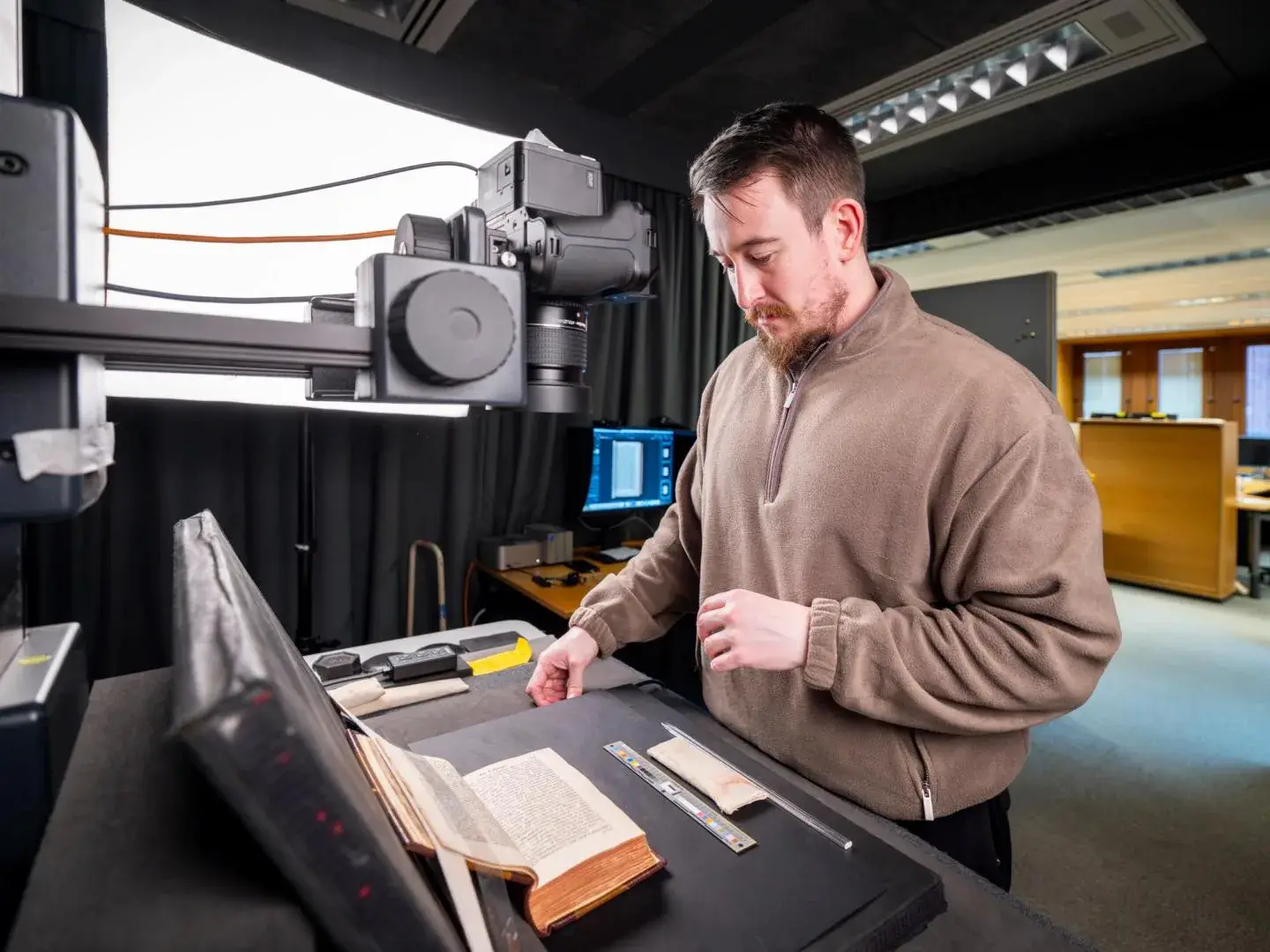 A British Library technician digitises an older volume with a camera above the open book