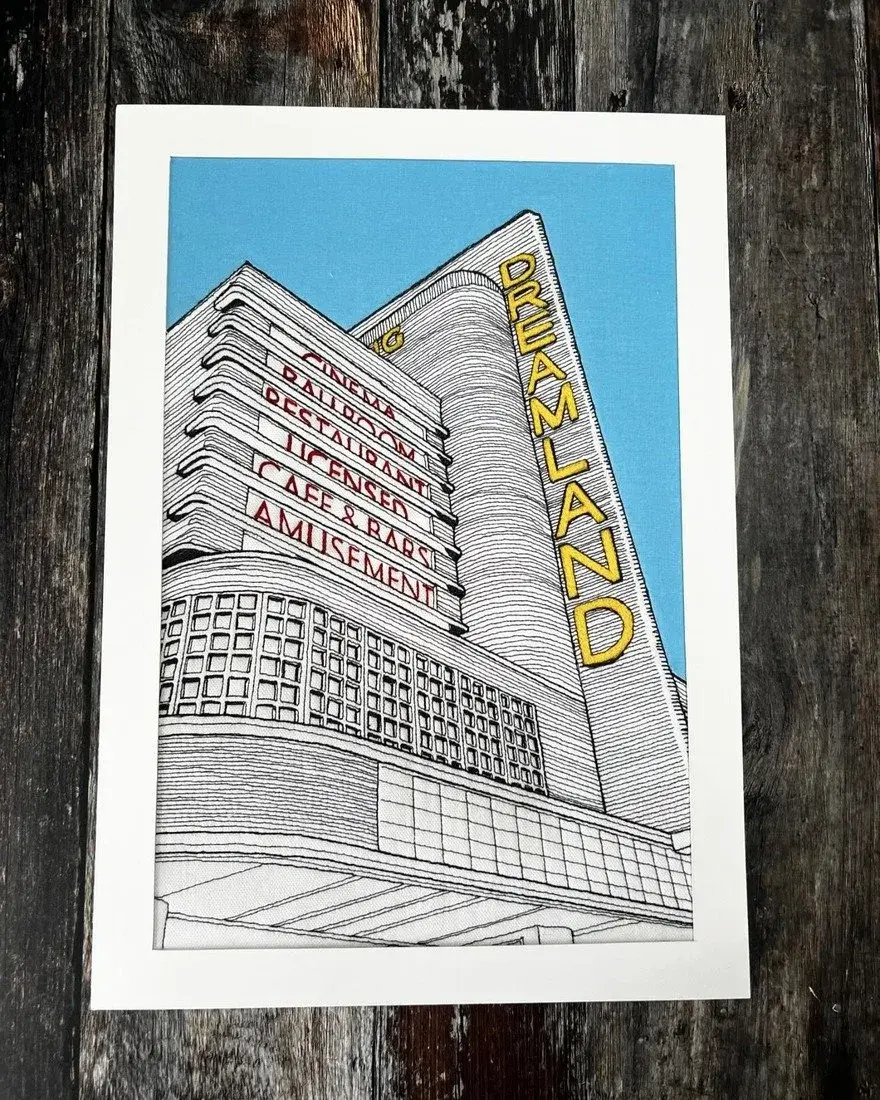 Thread embroidery of the art deco Dreamland facade with its vertical sign, against a blue sky