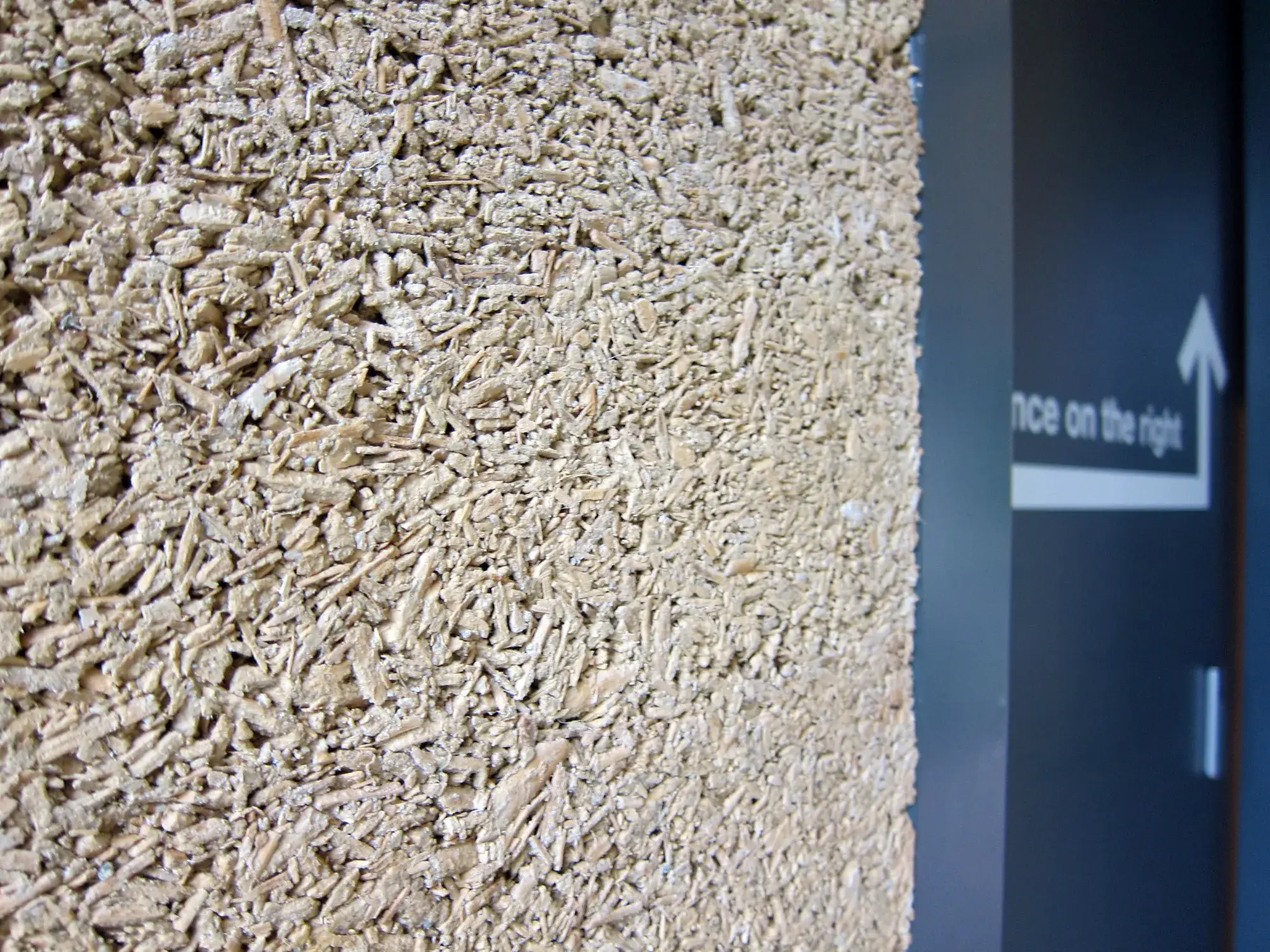 Gros plan sur un mur en chanvre-chaux montrant la texture du mélange
