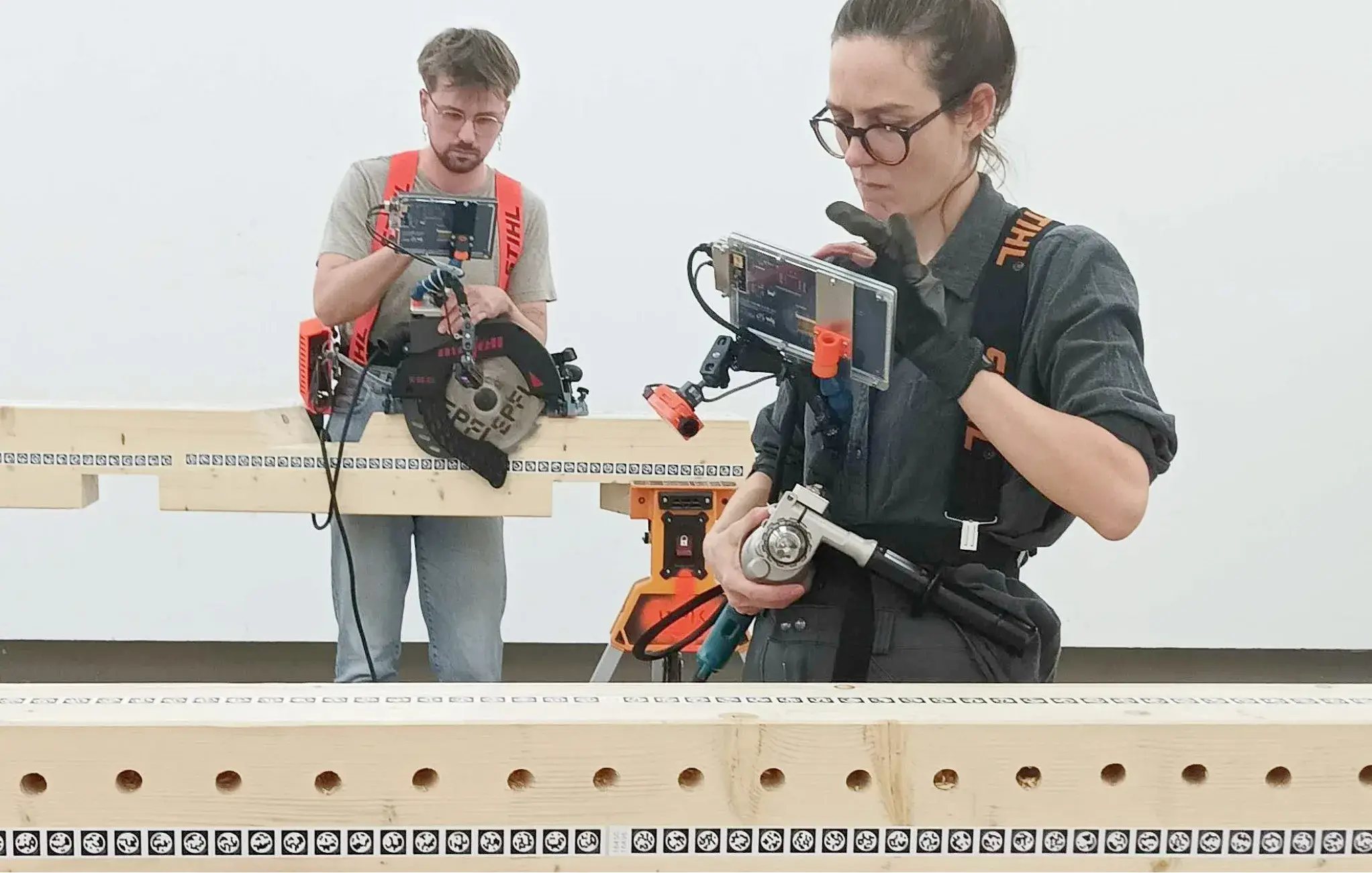 Two users test Augmented Carpentry with screen-guided saw and drill operations