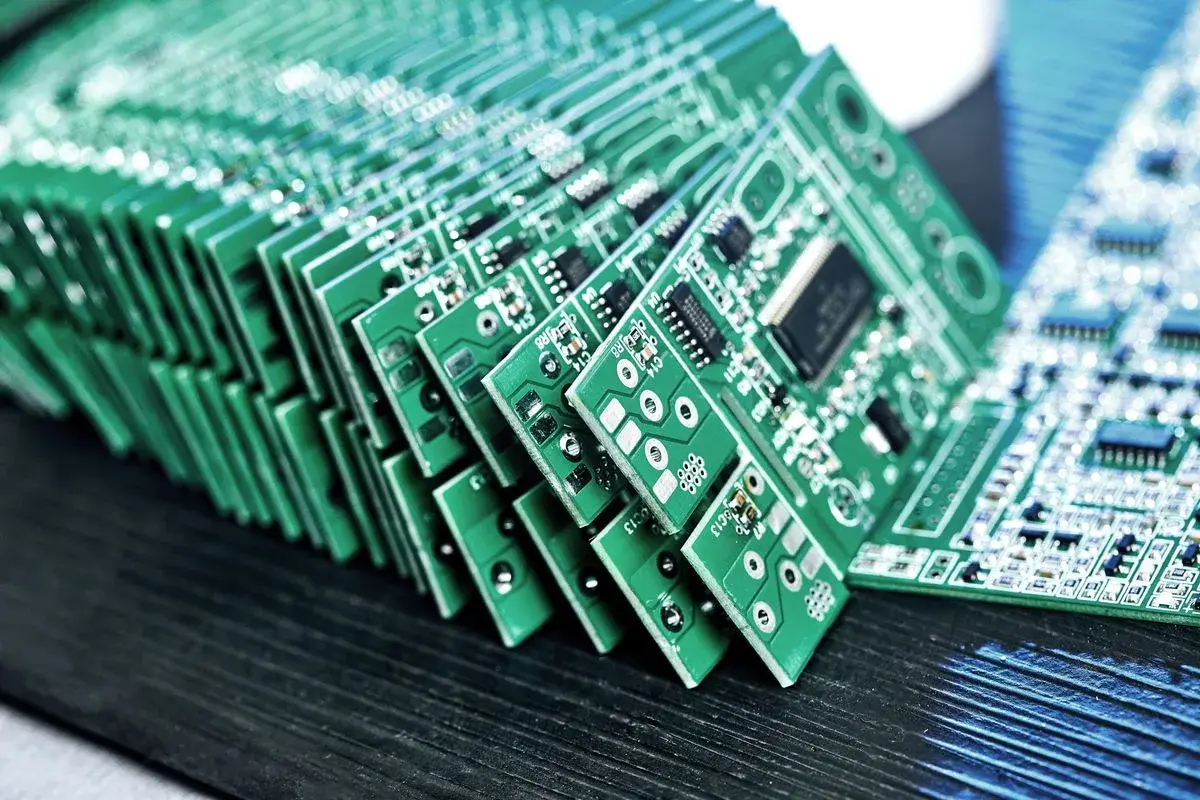 Stacked green printed circuit boards with electronic components on a work surface