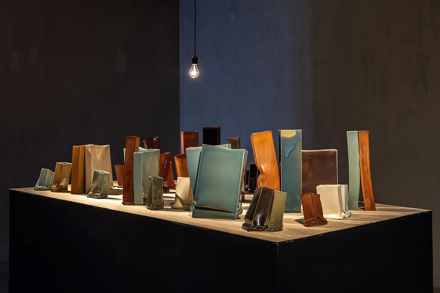 Vue de l'installation Noir C'est Noir d'Emmanuel Boos montrant plusieurs volumes en porcelaine sombre
