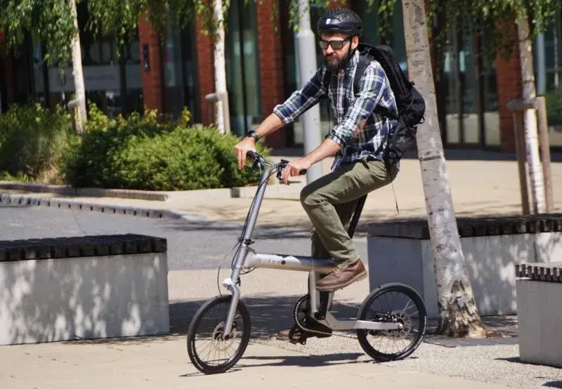 A rider on the FLIT M2i folding electric bike in an urban setting
