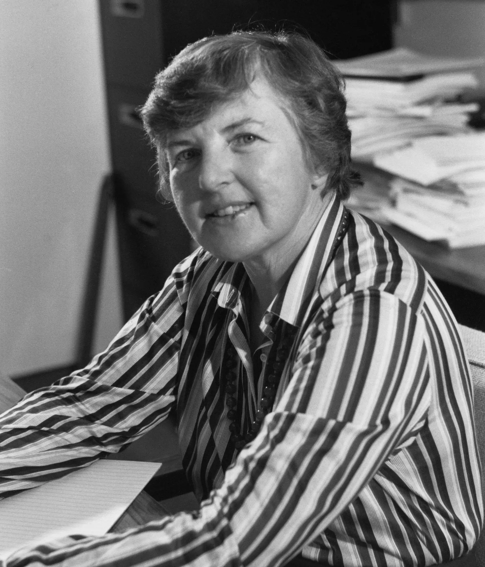 Black-and-white portrait of Frances Allen at her desk wearing a striped shirt