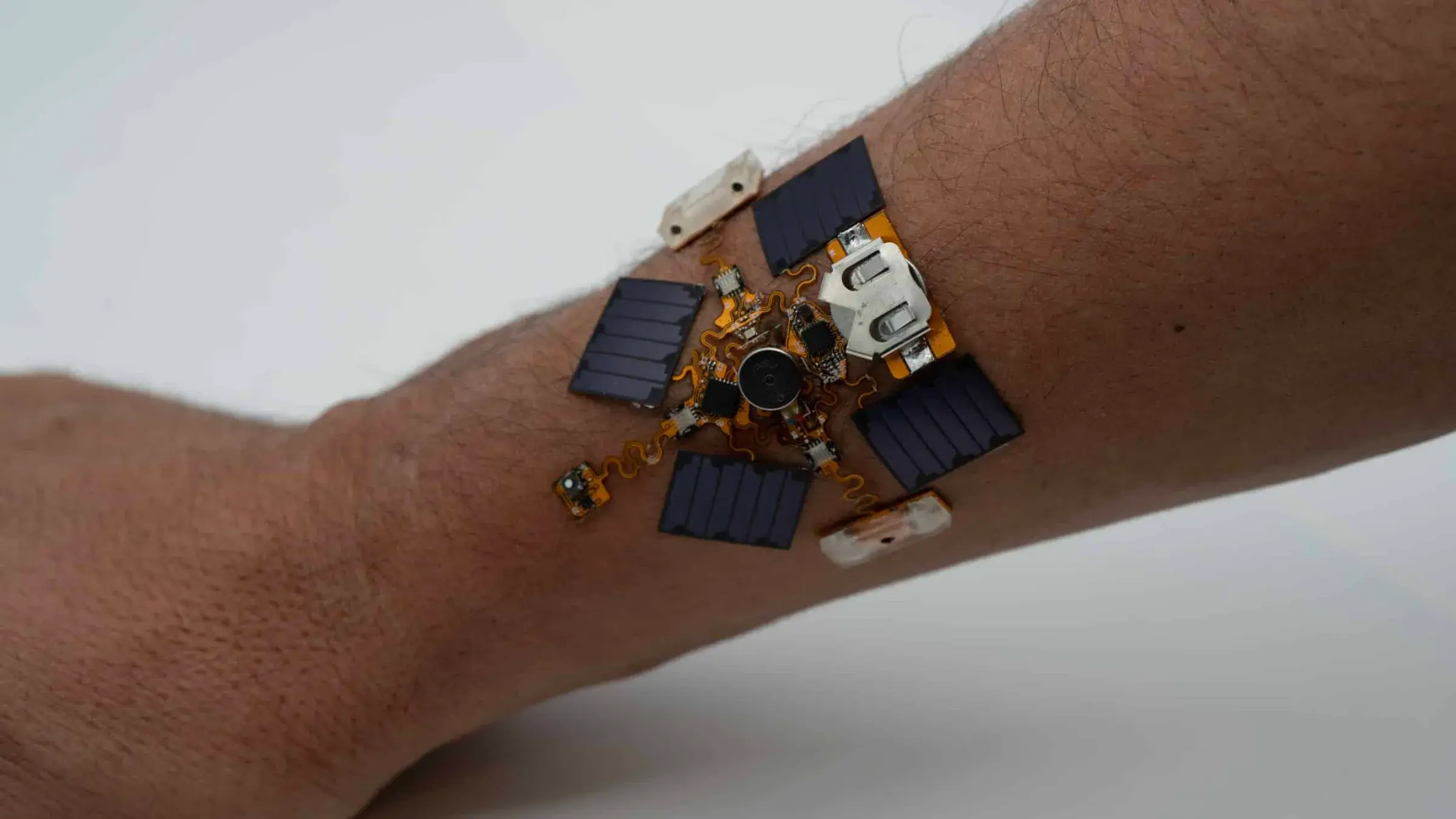 Patch capteur portable carré posé à côté de composants électroniques