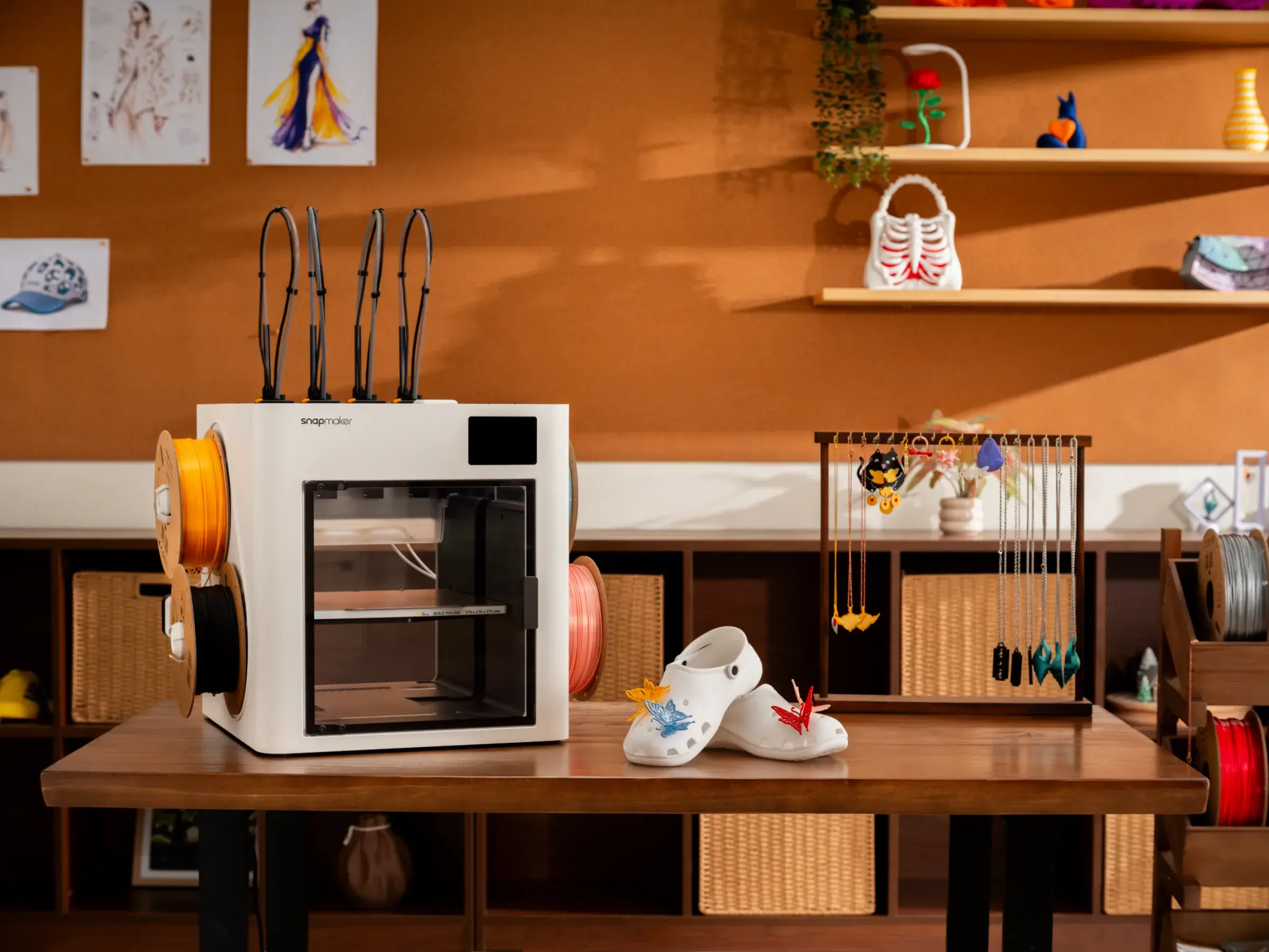 A 3D printer sitting on a desk with a finished white TPU clog resting nearby