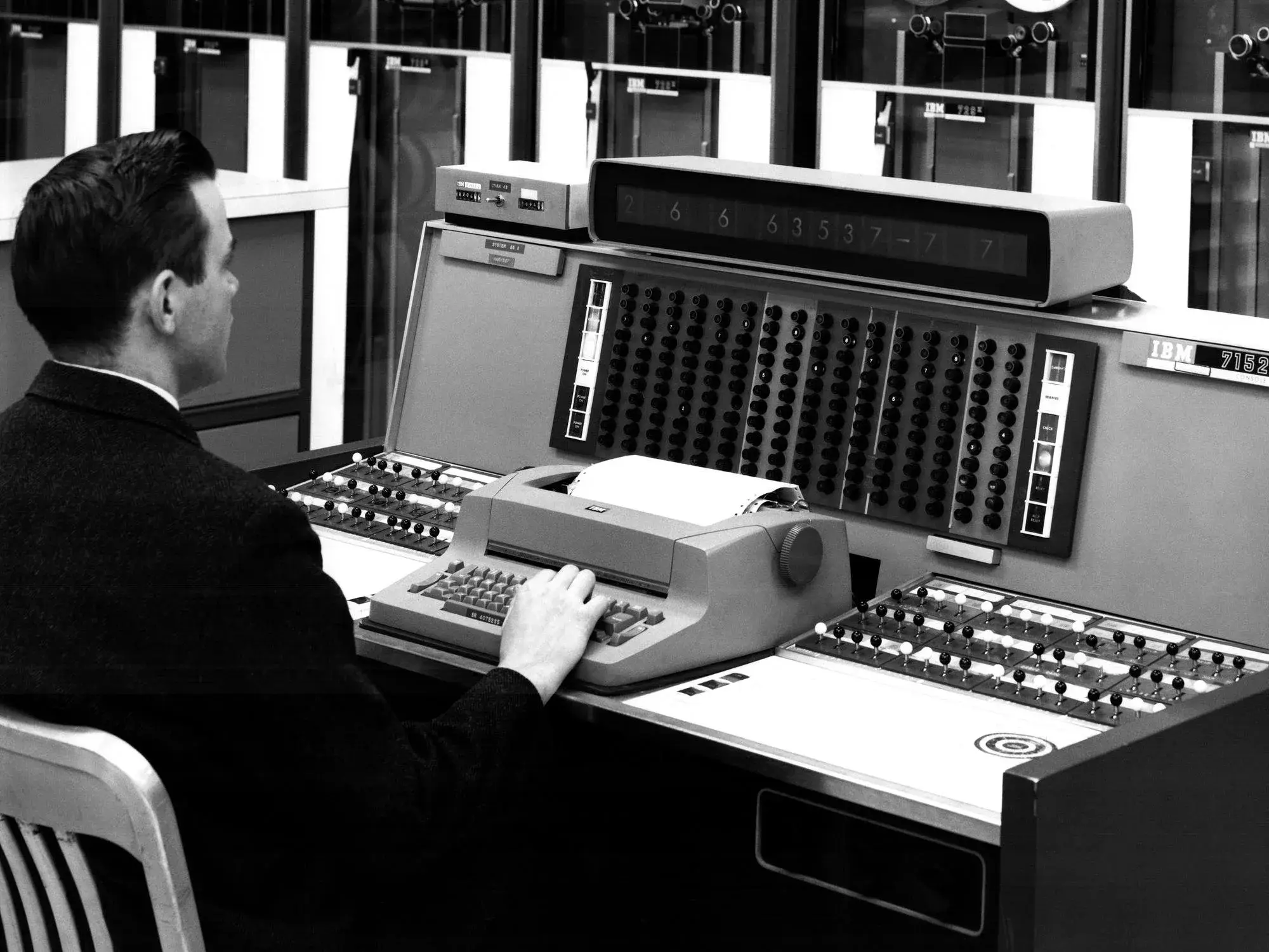 An operator types on a repurposed Selectric typewriter console with computer equipment behind