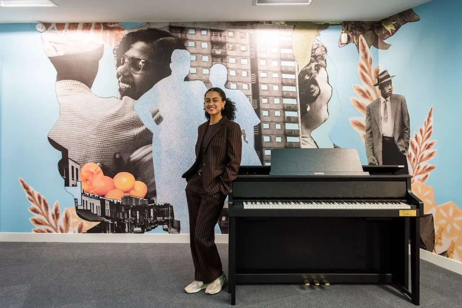 Jazz Grant devant la fresque To Travel This Ship installée à Hackney Central Library
