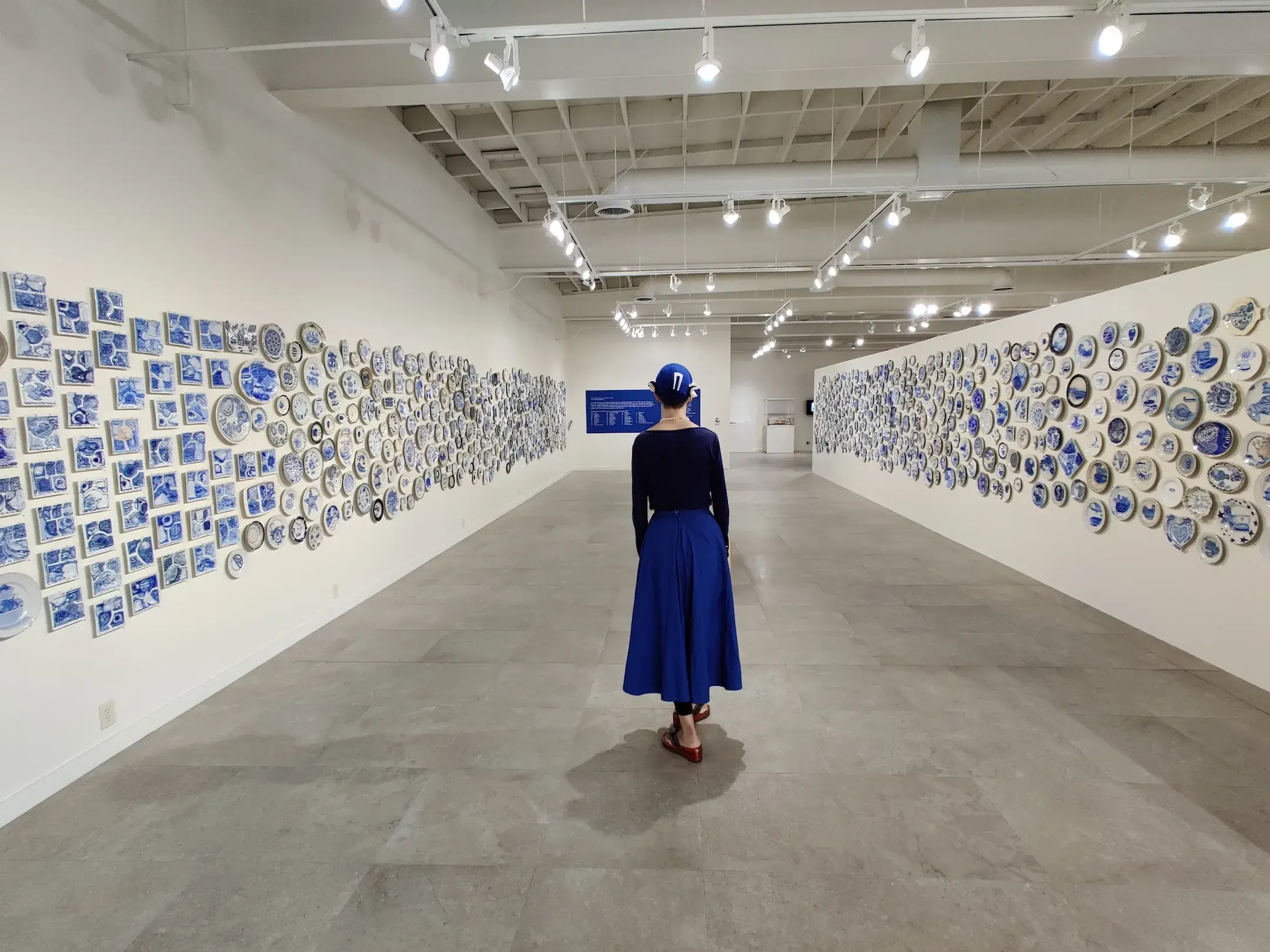 A wall covered with plates from Julie Green's The Last Supper in an exhibition