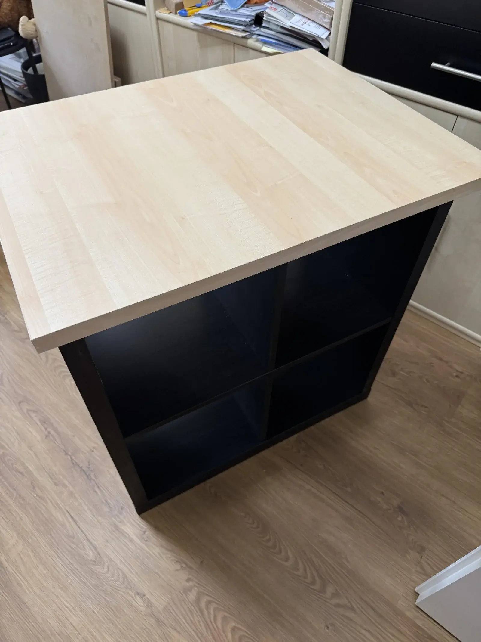 Workbench built from a black KALLAX unit topped with a large desk top, with storage