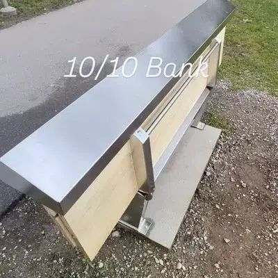 Public bench in Lausanne with its wooden seat folded beneath a metal cap