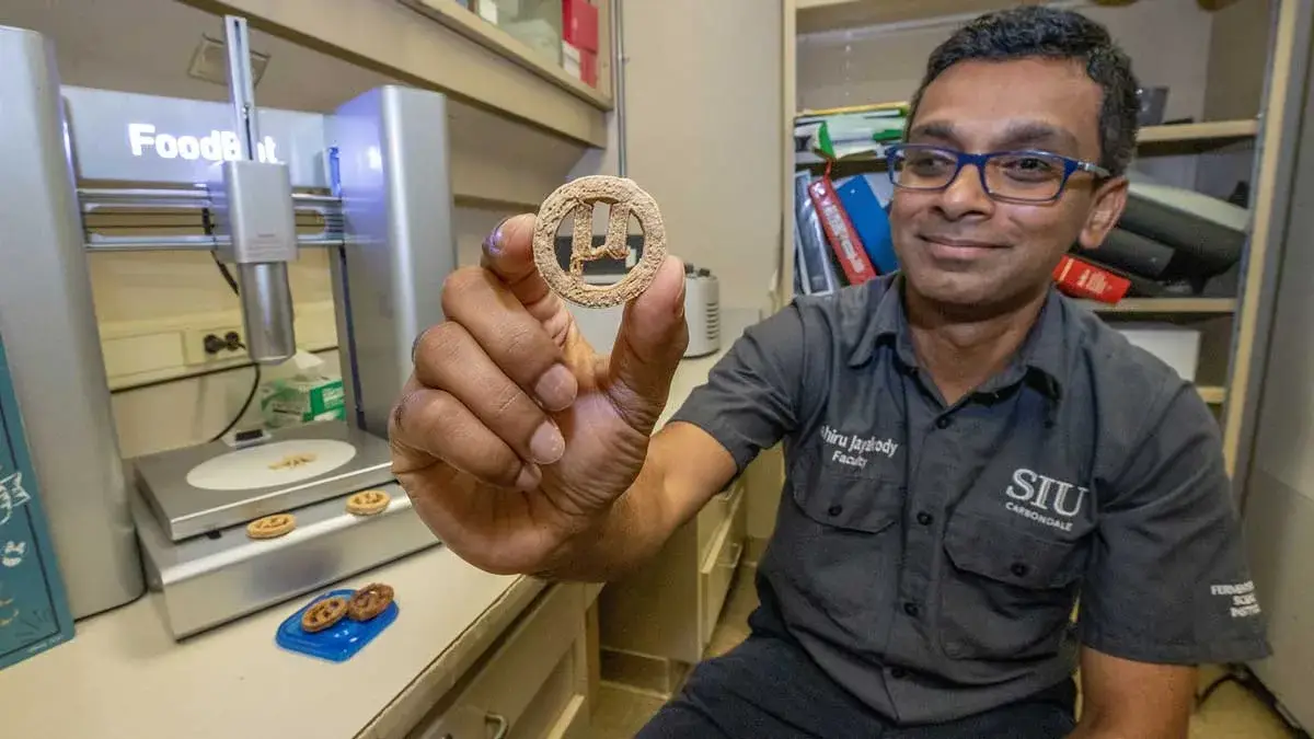 Lahiru Jayakody tient un prototype de cookie µBites dans un laboratoire de Southern Illinois University
