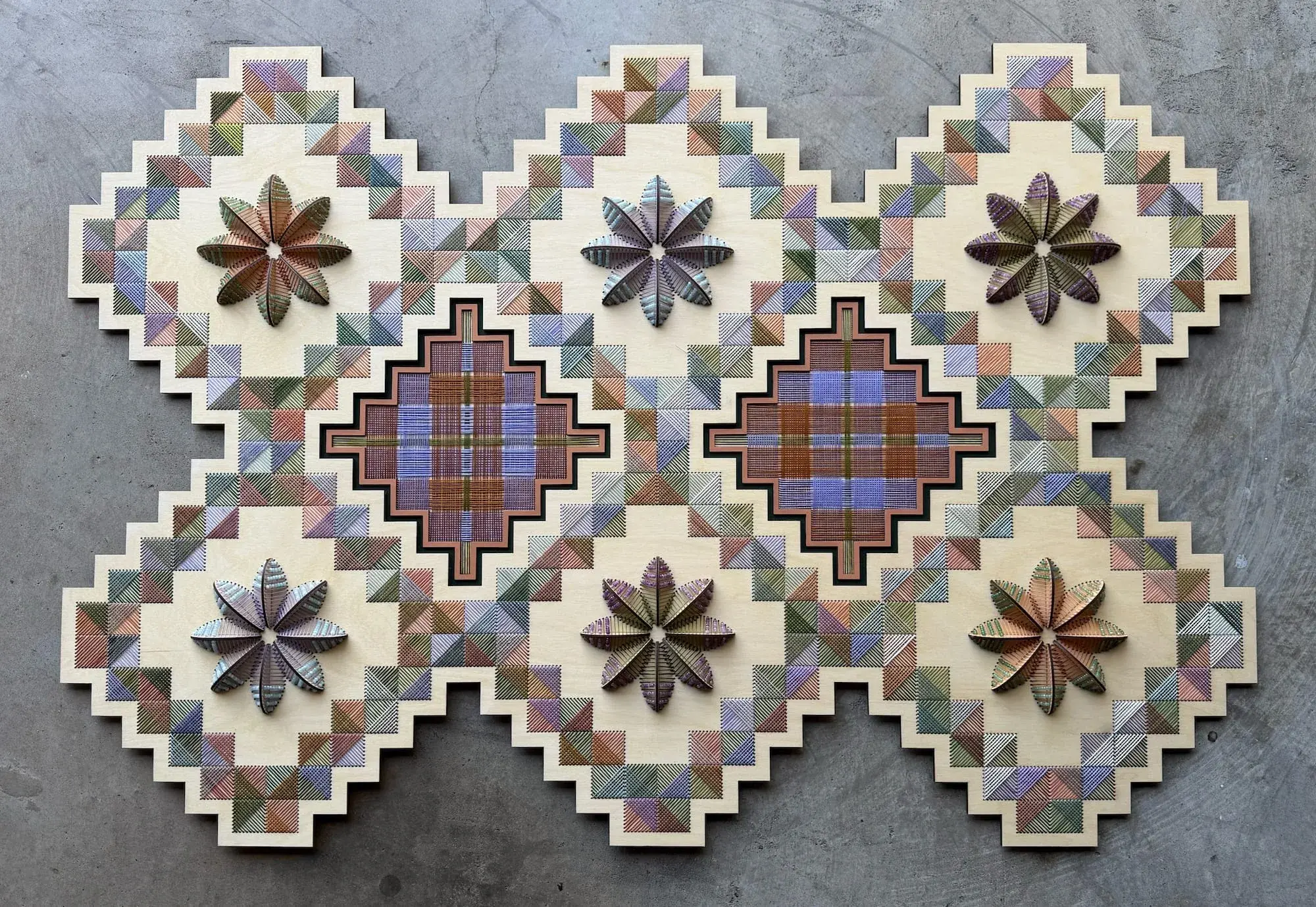 Relief en bois et fil de Nosheen Iqbal : champs géométriques en escalier brodés de couleurs sourdes, fleurs tridimensionnelles détachées du panneau