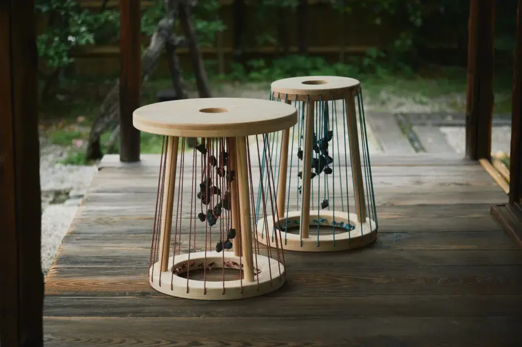 Tabouret kumino avec cordons rouges et pierres de lave