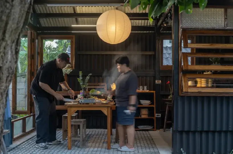 Cuisine ouverte de Sala Kin Khao, avec structure acier sombre et éléments de bois réemployés
