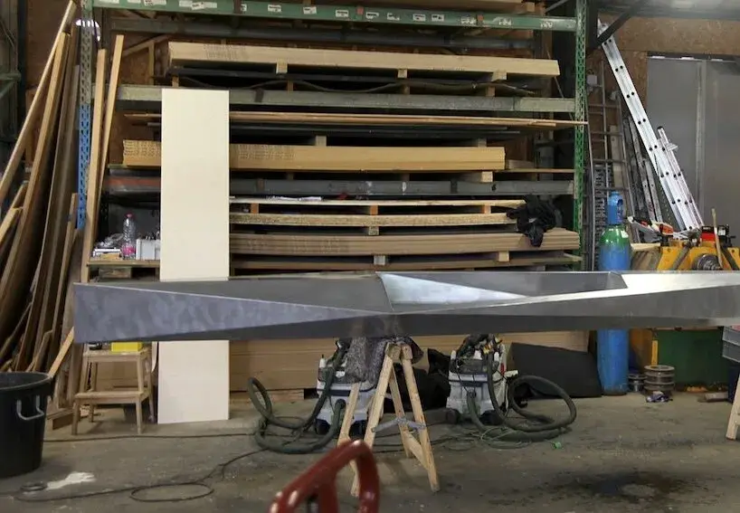 Sharp folded-aluminum kayak with cork seat on the water