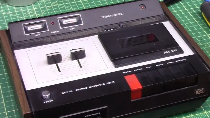 Realistic cassette deck opened on a workbench during servicing