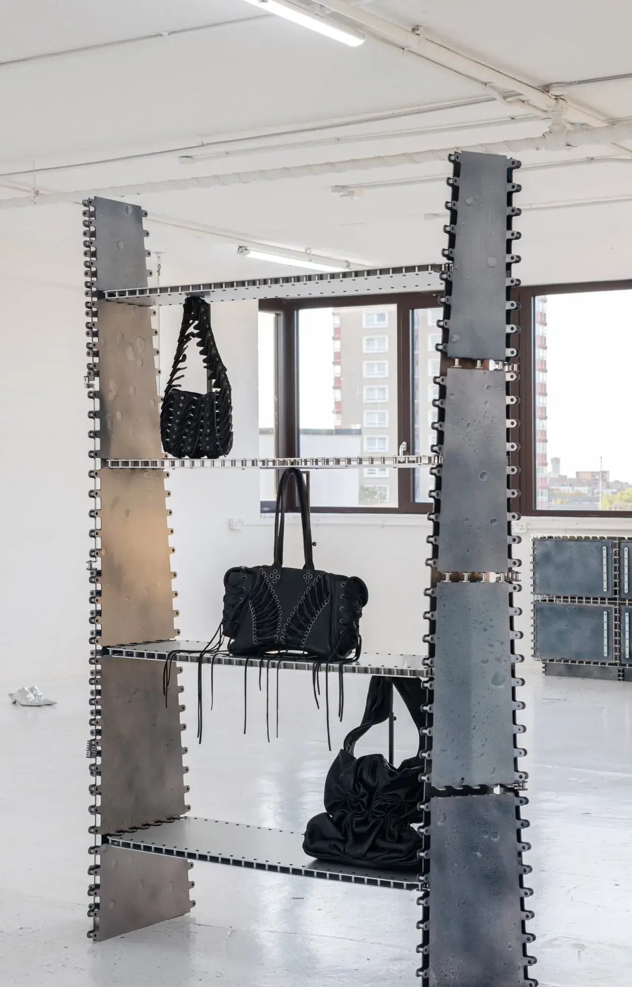 Meuble haut en aluminium coloré dont les arêtes sont ponctuées de nombreux rivets
