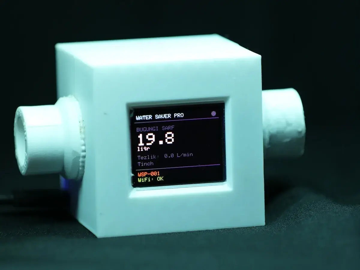 Water Saver Pro prototype: white enclosure with two pipe fittings, display showing “Bugungi sarf 19.8 litr” and “WiFi: OK”
