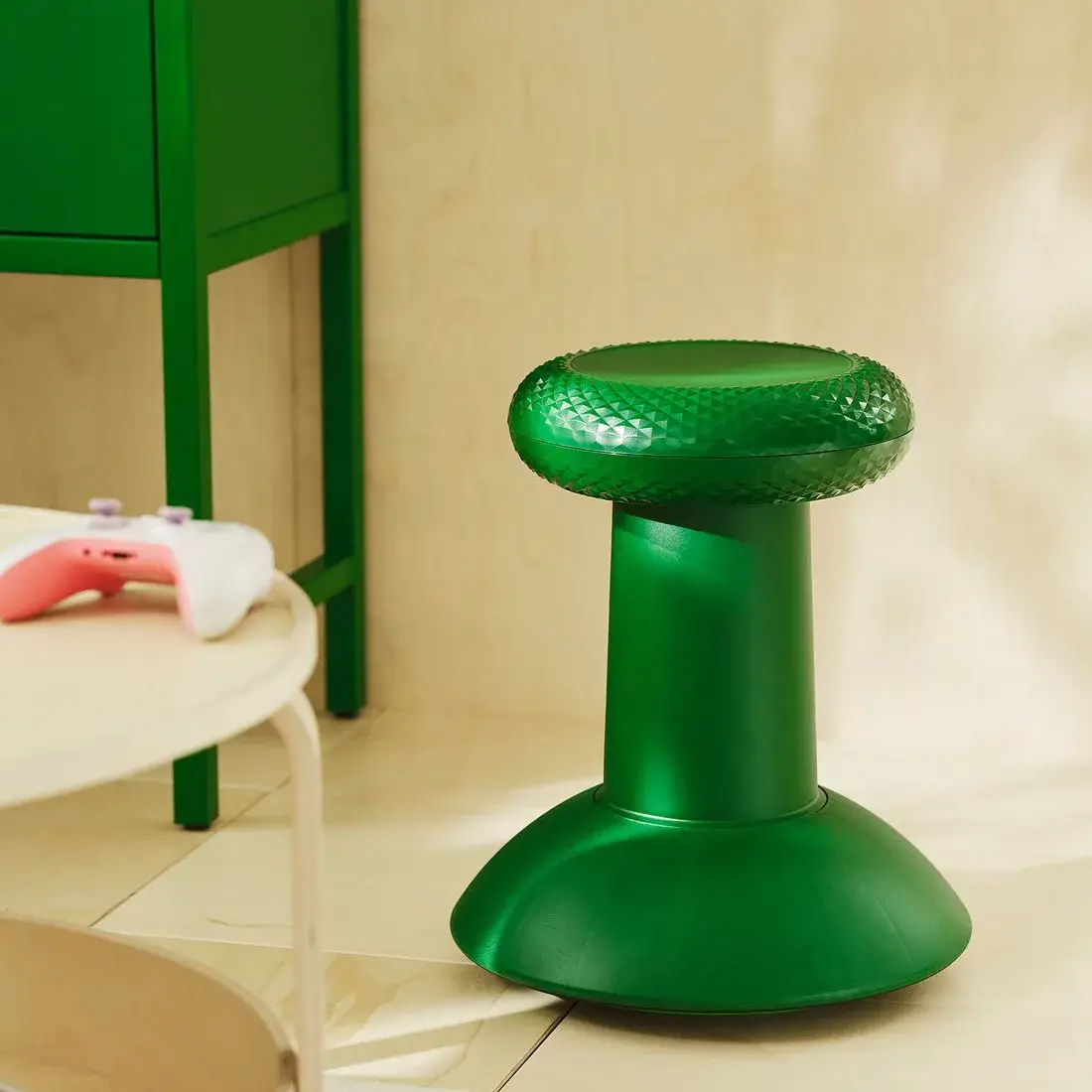 Tabouret YXSTABY vert dans un intérieur, près d'une table ronde et d'un contrôleur